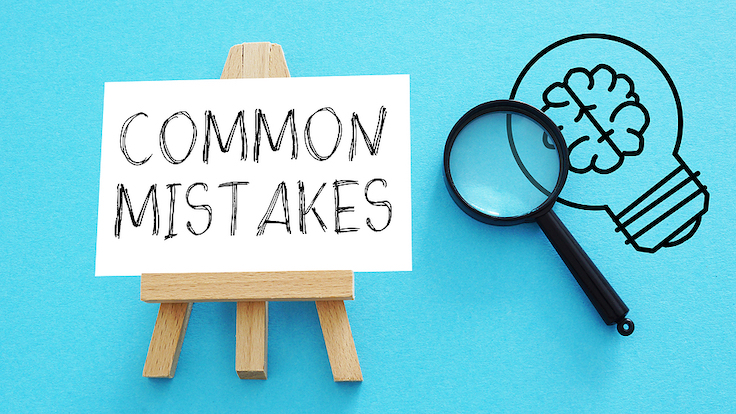 A wooden easel holding a card with the words common mistakes on it and to the right a magnifying glass and a lightbulb with the outline of a brain inside it