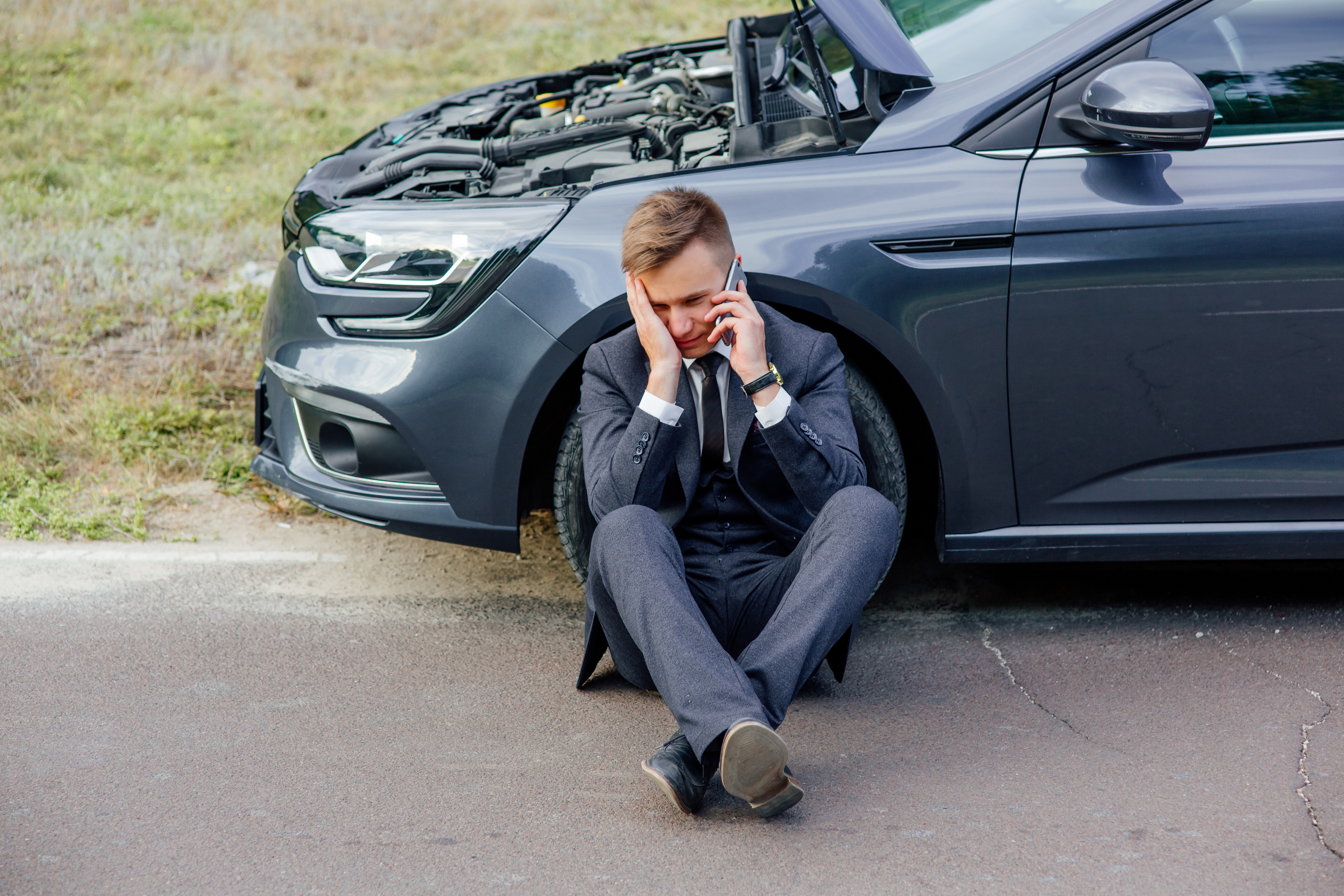 Upset man on a phone with a broken down car